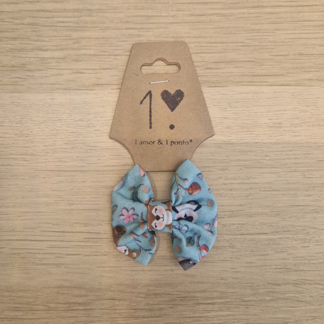 Laço azul com padrão de flores e animais em cartão castanho sobre madeira clara