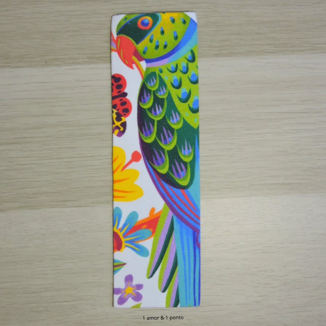 Marcador de livro colorido com papagaio e flores sobre madeira clara