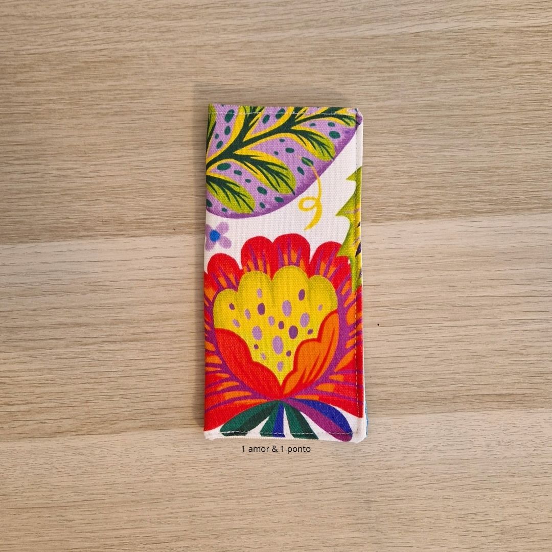 Capa de tecido colorida com padrão floral sobre madeira clara