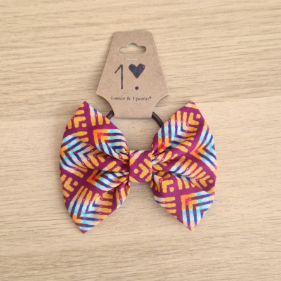 Laço de tecido colorido com padrão geométrico e etiqueta de cartão