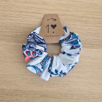 Elástico de cabelo scrunchie com padrão floral azul, branco e vermelho e etiqueta com texto '1 amor & 1 portão'