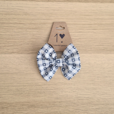 Laço para cabelo xadrez branco e azul em cartão sobre madeira clara