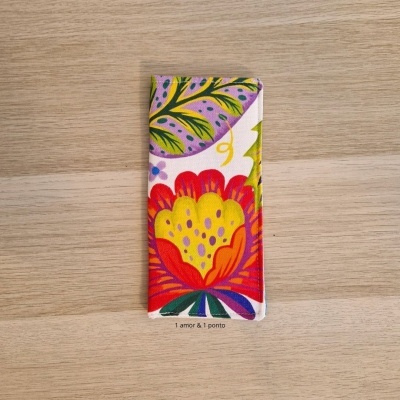 Capa de tecido colorida com padrão floral sobre madeira clara