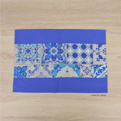 Tapete retangular azul com faixa central decorada por padrões de azulejos portugueses.