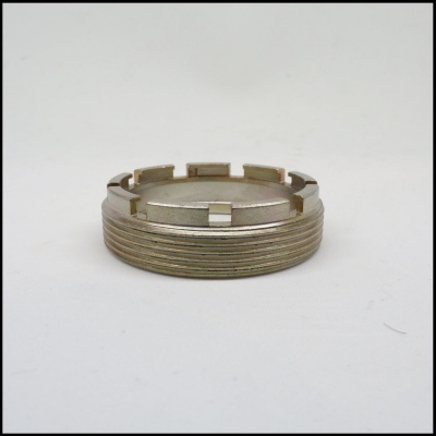 Anel metálico prateado com nervuras e entalhes em fundo branco