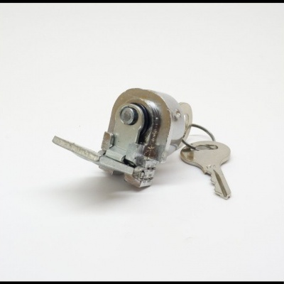 Cilindro de fechadura metálico com chave prateada sobre superfície branca