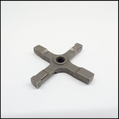 peça metálica em forma de cruz com furo roscado no centro sobre fundo branco