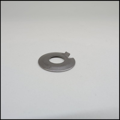 Arruela metálica prateada com fecho numa superfície branca