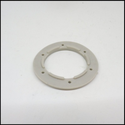 Anel plástico cinzento claro com orifícios e saliências em fundo branco