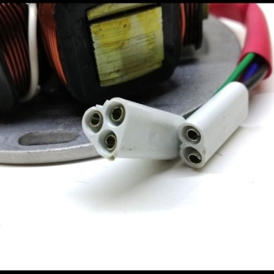 Conetores brancos com fios coloridos e componentes com fios de cobre numa superfície metálica