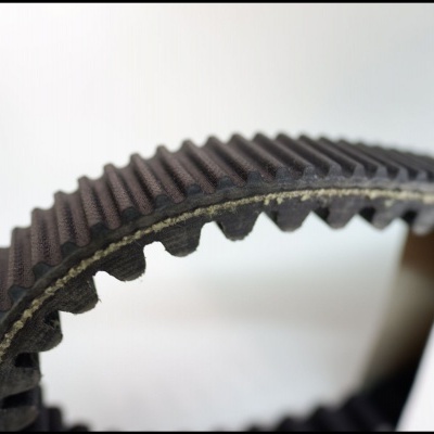 Correia dentada preta em borracha com reforço têxtil, vista de perto