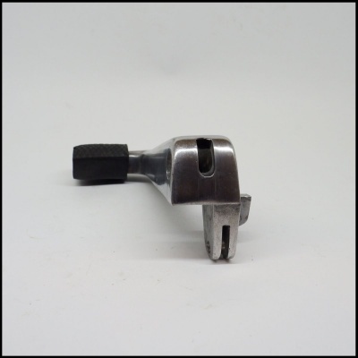 Peça metálica prateada com empunhadura preta sobre fundo branco