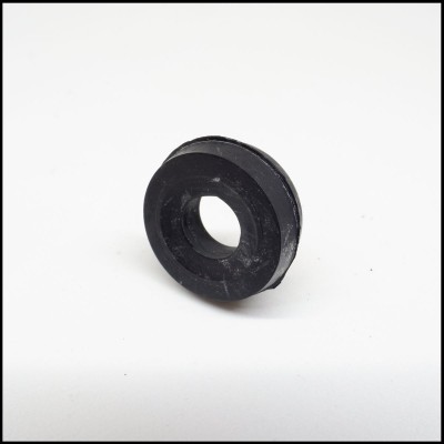 Peça circular preta com orifício central sobre superfície branca