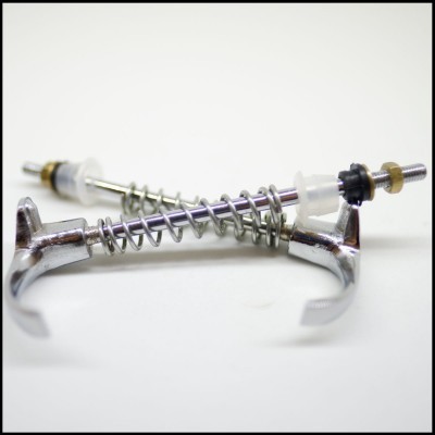 Dispositivos metálicos com molas e partes plásticas sobre fundo branco