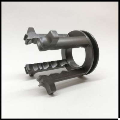 Peça plástica cinzenta com três ganchos e base redonda