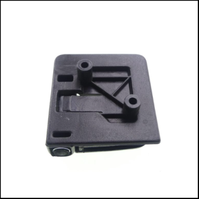 Peça plástica preta quadrada com relevo sobre fundo branco