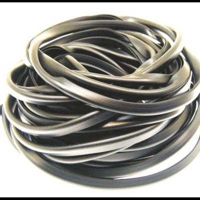 Rolo de tubo flexível preto enrolado em superfície branca