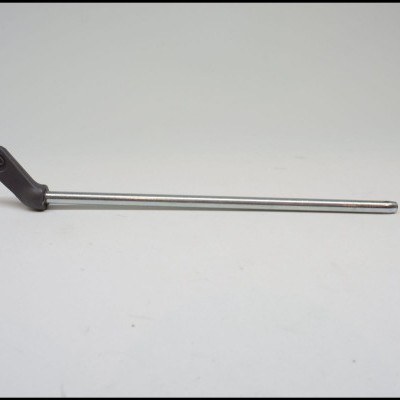 Bastão metálico fino com ponta preta em ângulo sobre fundo branco