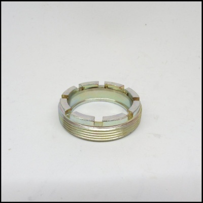 Porca metálica castelo dourada com fendas em superfície branca