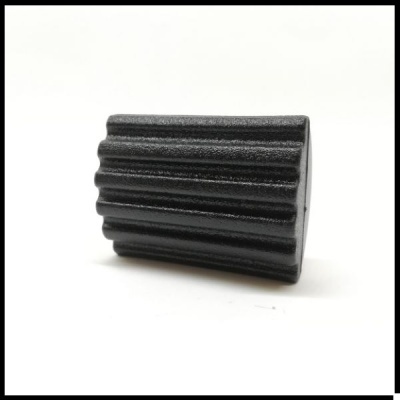 Peça preta cilíndrica com textura estriada