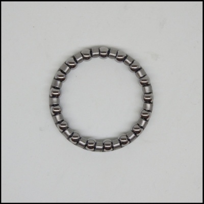 Anel metálico feito de pequenos cilindros articulados sobre fundo branco