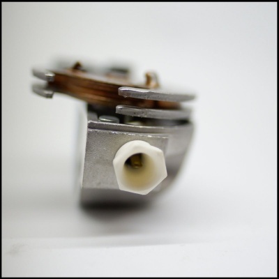 Componente elétrico metálico com parafuso branco em fundo branco