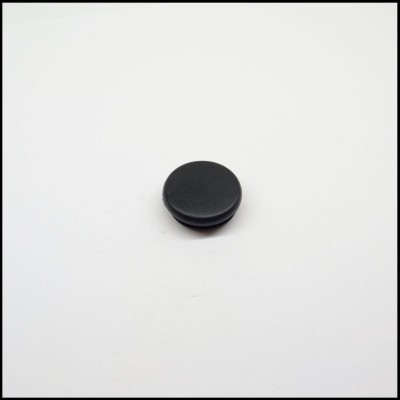 Botão redondo preto sobre superfície branca