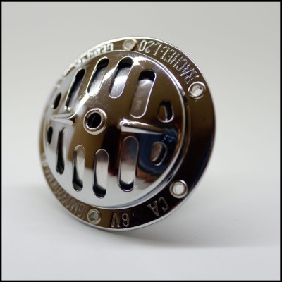 Peça metálica circular com fendas e inscrições em relevo