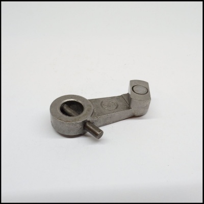 Peça metálica industrial prateada sobre fundo branco