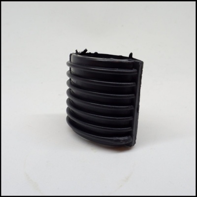 Peça pequena preta de plástico com estrutura estriada sobre fundo branco