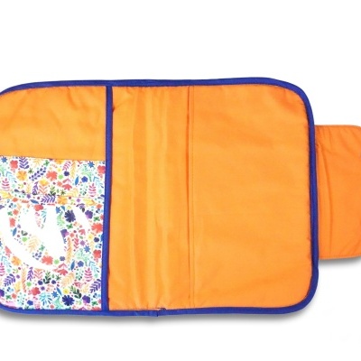 Estojo aberto de tecido laranja com bolso floral transparente e bordas azuis