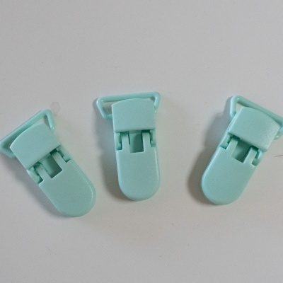 Três clips de plástico azuis claros sobre fundo branco