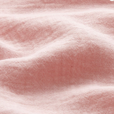 Tecido rosa claro com textura suave e enrugada