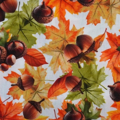 Tecido branco com padrão colorido de folhas de outono e bolotas.