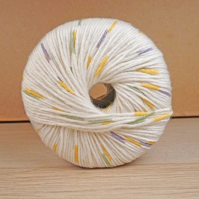 Novelo de lã branca com risquinhos coloridos em fundo de madeira.