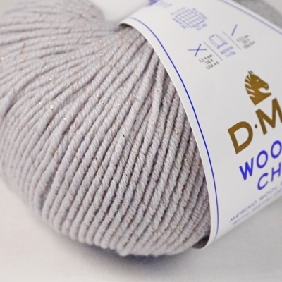 Novelo de lã cinzento claro com fios dourados e etiqueta branca com texto azul e dourado