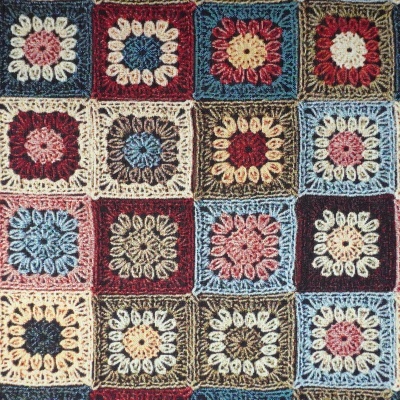 Manta de croché com quadrados coloridos em padrão floral.