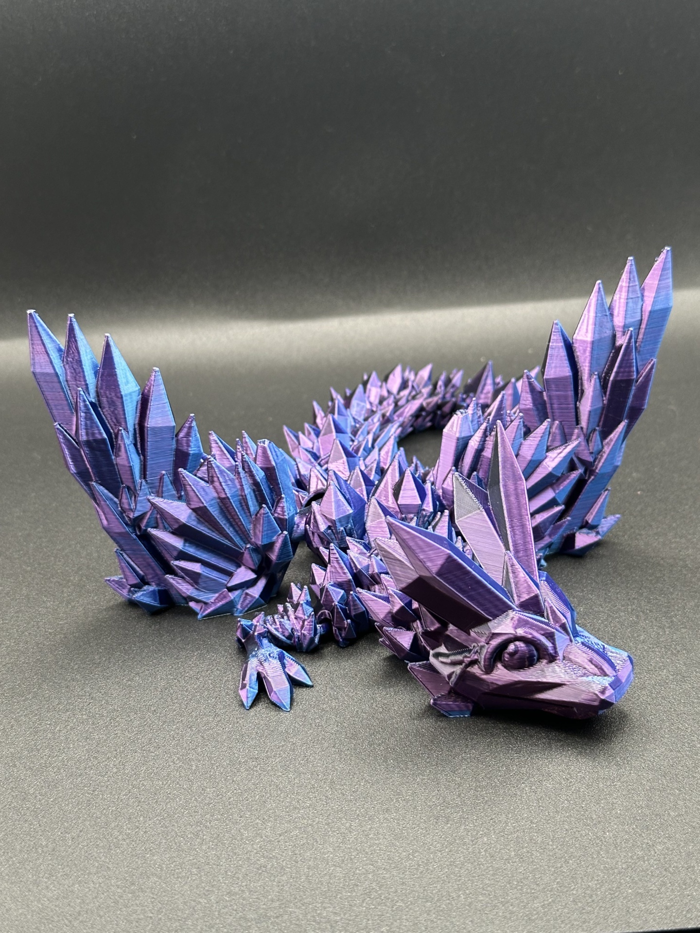 Estatueta de dragão azul e violeta em textura geométrica