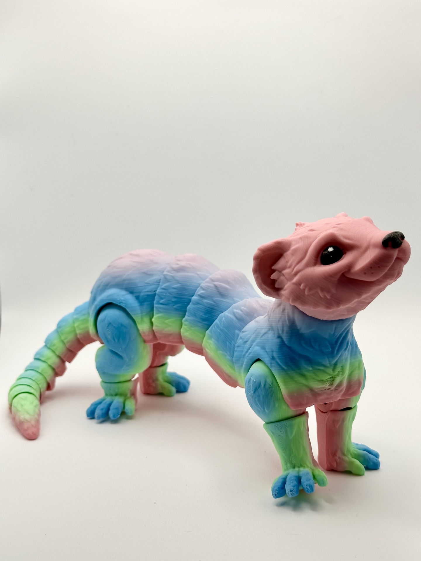 Figura articulada de animal colorido em tons pastel com várias articulações