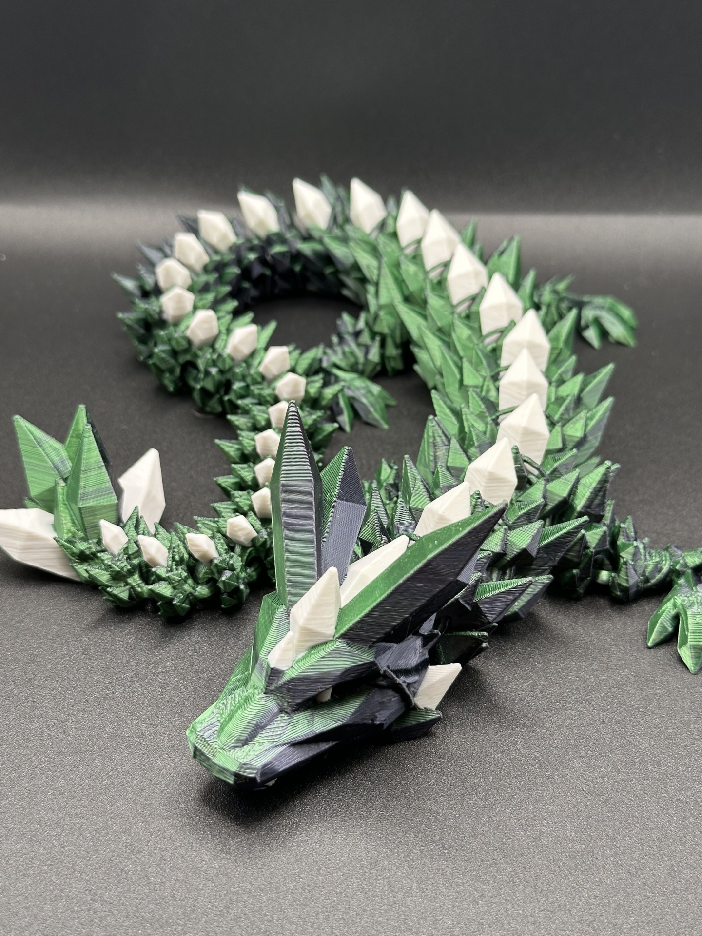 Figura geométrica de dragão verde com branco e preto sobre fundo preto