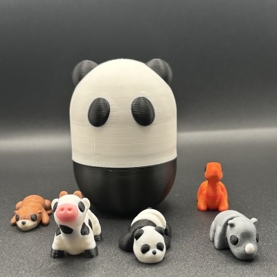 Figuras de animais em miniatura coloridas, com um panda grande ao centro e vários animais pequenos ao redor