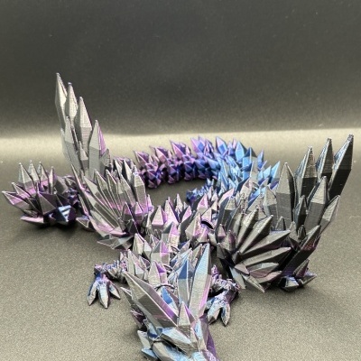 Dragão decorativo preto com picos triangulares metálicos em roxo e azul