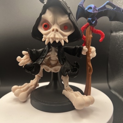 Boneco esqueleto com capa preta e cajado com morcego azul