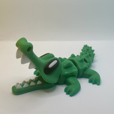 Brinquedo de crocodilo verde de plástico com dentes brancos e olhos grandes