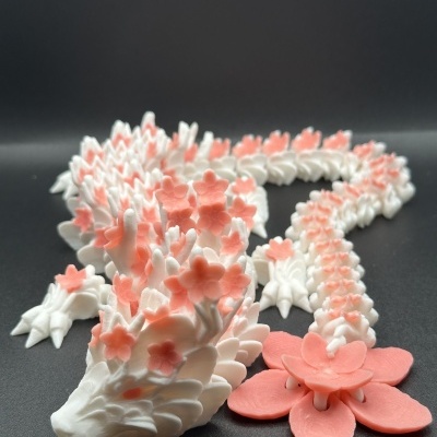 Escultura de dragão branco com flores cor-de-rosa em fundo preto