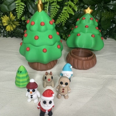 Figuras plásticas de Natal com árvores e bonecos pequenos em pano claro e fundo de folhas verdes