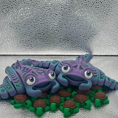 Estatuetas de tartarugas roxas com padrões azuis e miniaturas verdes de tartarugas sobre fundo prateado