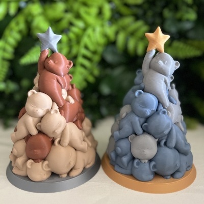 Objetos decorativos em forma de pirâmide de ursinhos empilhados em tons terra e azul com estrelas no topo.