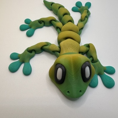 Boneco lagarto verde e azul com olhos grandes e corpo segmentado