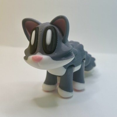 Brinquedo de gato cinzento com branco e olhos grandes